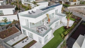 Ein modernes Mehrfamilienhaus mit Dachpool, Außenbereich und gepflegtem Garten.