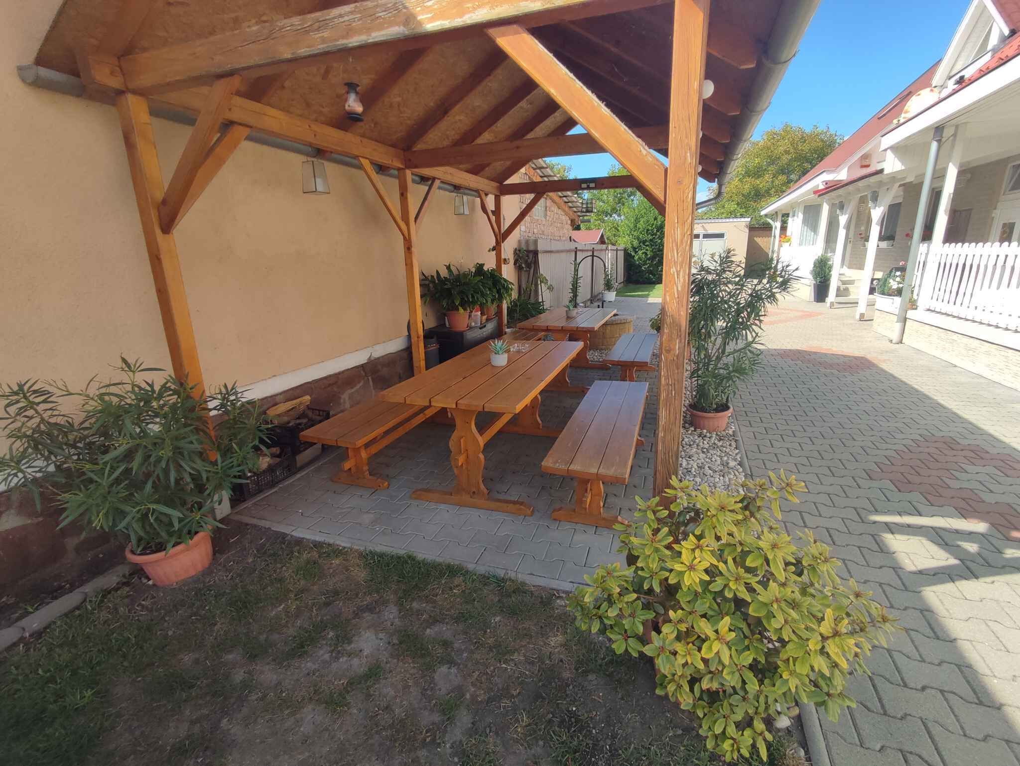 Eine Terrassenausstattung mit Holzbänken und Topfpflanzen.