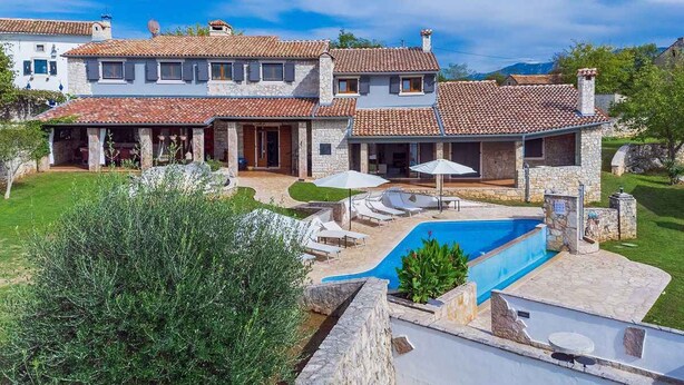 A two-story house with a swimming pool, stone exterior, and a well-maintained garden. - Villa with swimming pool, sauna and indoor pool (Nedešćina)