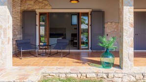 An outdoor patio with stone walls, a table with chairs, and a potted plant. - Villa with swimming pool, sauna and indoor pool (Nedešćina)