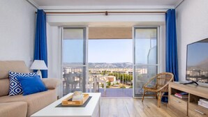 A modern living room with a sofa, coffee table, and a TV on a wooden cabinet. - Strand II by Interhome (Jávea)