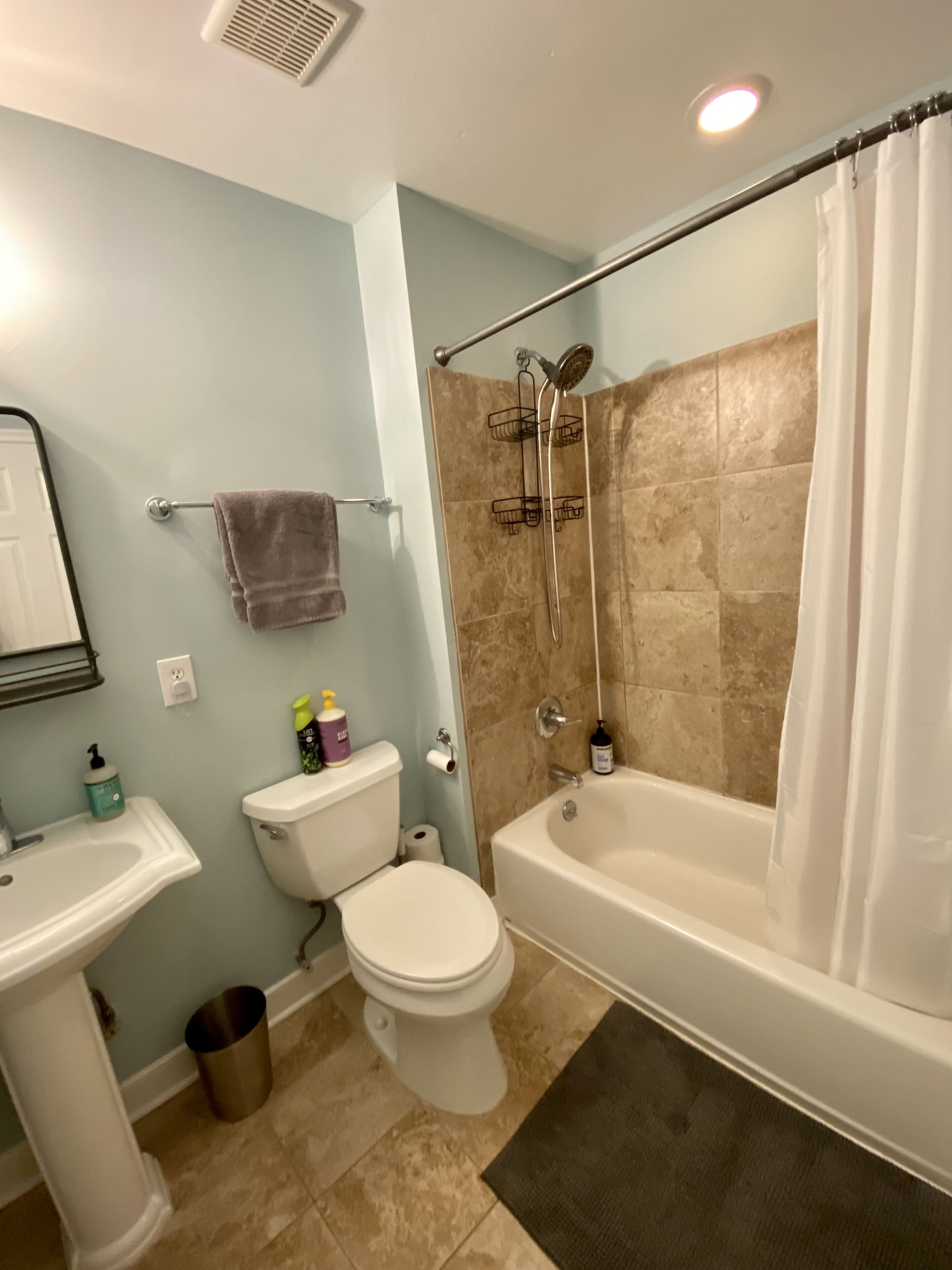 Ein Badezimmer mit Toilette, Waschbecken, Badewanne und Dusche.