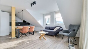 Eine moderne Loft-Wohnung mit Essbereich, einer Couch und einem Sessel.