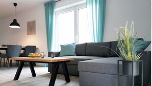 Una sala de estar moderna con un sofá, una mesa de centro y una planta en maceta.