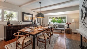 Un espace repas comprenant une table en bois, des chaises et un luminaire suspendu.