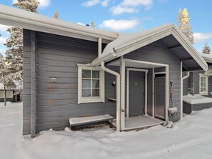 Et toetagers hus med en overdækket veranda og en dør ind til huset.