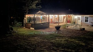 A house with a covered porch, outdoor seating, and a fire pit.