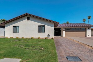 A two-story house with a garage, a paved driveway, and a well-maintained lawn. - Perfect Getaway! Private Heated POOL, Dog Friendly, Close to ASU, Shopping & Dining! (Scottsdale)
