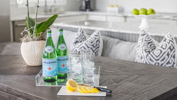 A dining table with Pellegrino water bottles, glasses, ice, and a lemon wedge. - Designer's Dream in Historic Charleston +Walk to King St and Dining (Charleston)