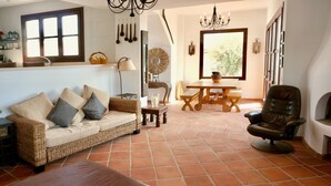 Un salon avec un canapé, un fauteuil en cuir, une table en bois et une cheminée.