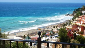 Une vue sur la côte, avec une plage, l’océan et des bâtiments.