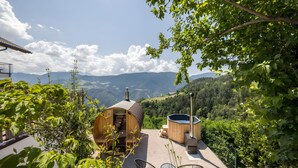 Un chalet en bois avec un jacuzzi et une vue sur les montagnes.