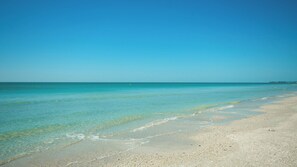 Uma praia com águas turquesa cristalinas e areal dourado.