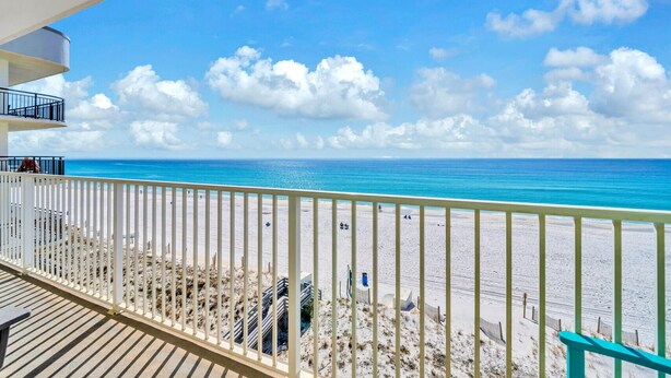 Ein Balkon mit Blick auf Strand und Meer.
