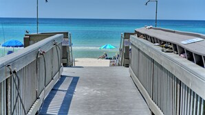 A wooden pier leading to a beach with a clear view of the ocean. - Sunrise Resort by BBG (Panama City Beach)