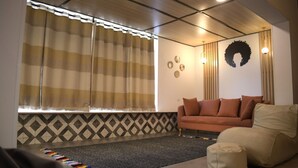 A living room with a sofa, a rug, and a window with curtains. - Egypt 5 - STAR Cozy 3 BR Villa with Garden (First 6th of October)