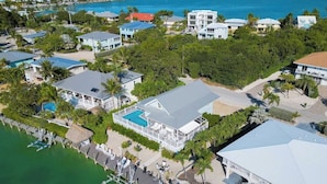 Luftaufnahme eines Küstenresorts mit mehreren Geb äuden, einem Jachthafen und einem großen Schwimmbecken.