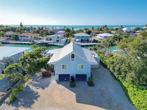 A coastal residential area with houses, a marina, and a clear view of the ocean.
