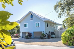 A two-story house with a garage, a covered porch, and a small garden area.