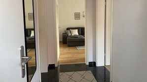Un pasillo que da a una sala de estar con sofá y alfombra.
