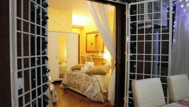 Habitación de hotel con cama, escritorio y silla. Tiene una ventana con cortinas y vistas al exterior.