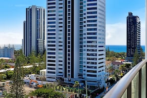 A high-rise building with multiple floors, surrounded by greenery and other buildings.