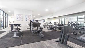 A gym with various exercise equipment, including treadmills, dumbbells, and weight machines. - 3BR Apartment Hinterland Views - Sierra Grand (Broadbeach)