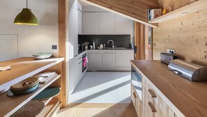 A modern kitchen with wooden beams, a built-in oven, and a stainless steel toaster. - New 8 Pax Apartment, Parking, Near Slopes (Les Belleville)