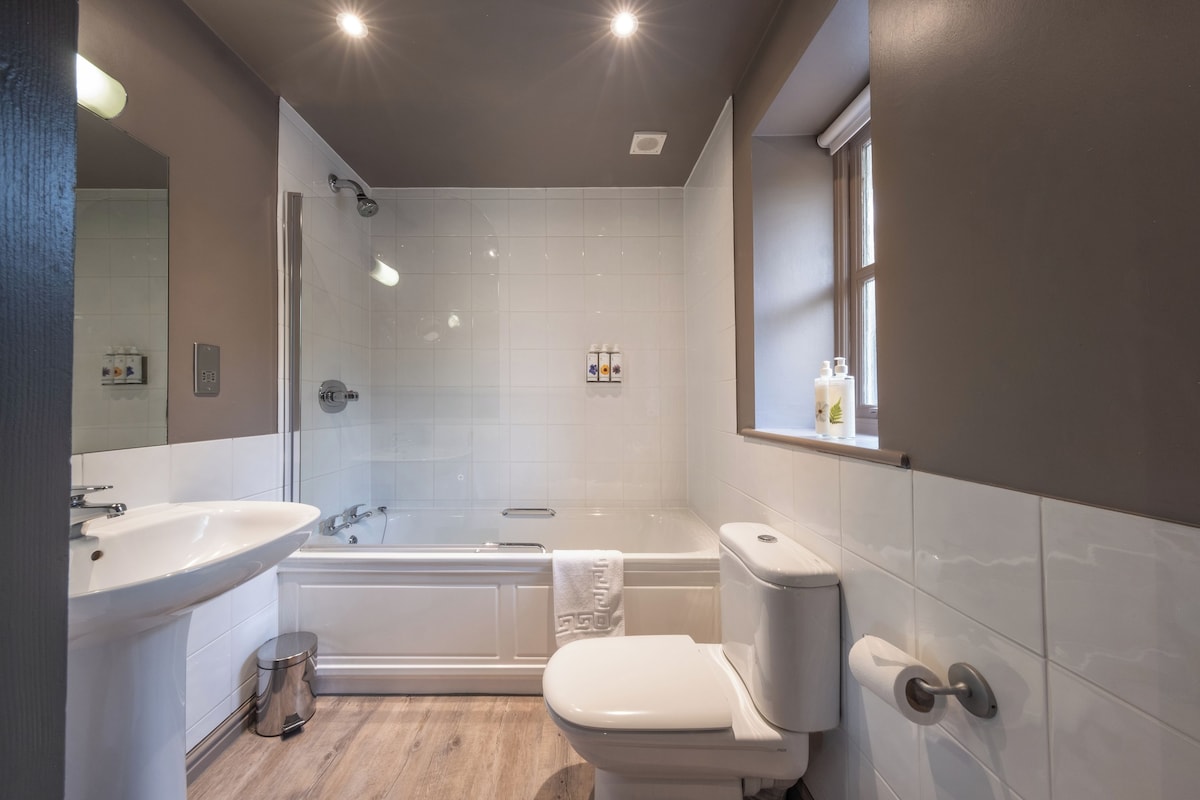 A modern bathroom with a sink, toilet, bathtub, and shower.