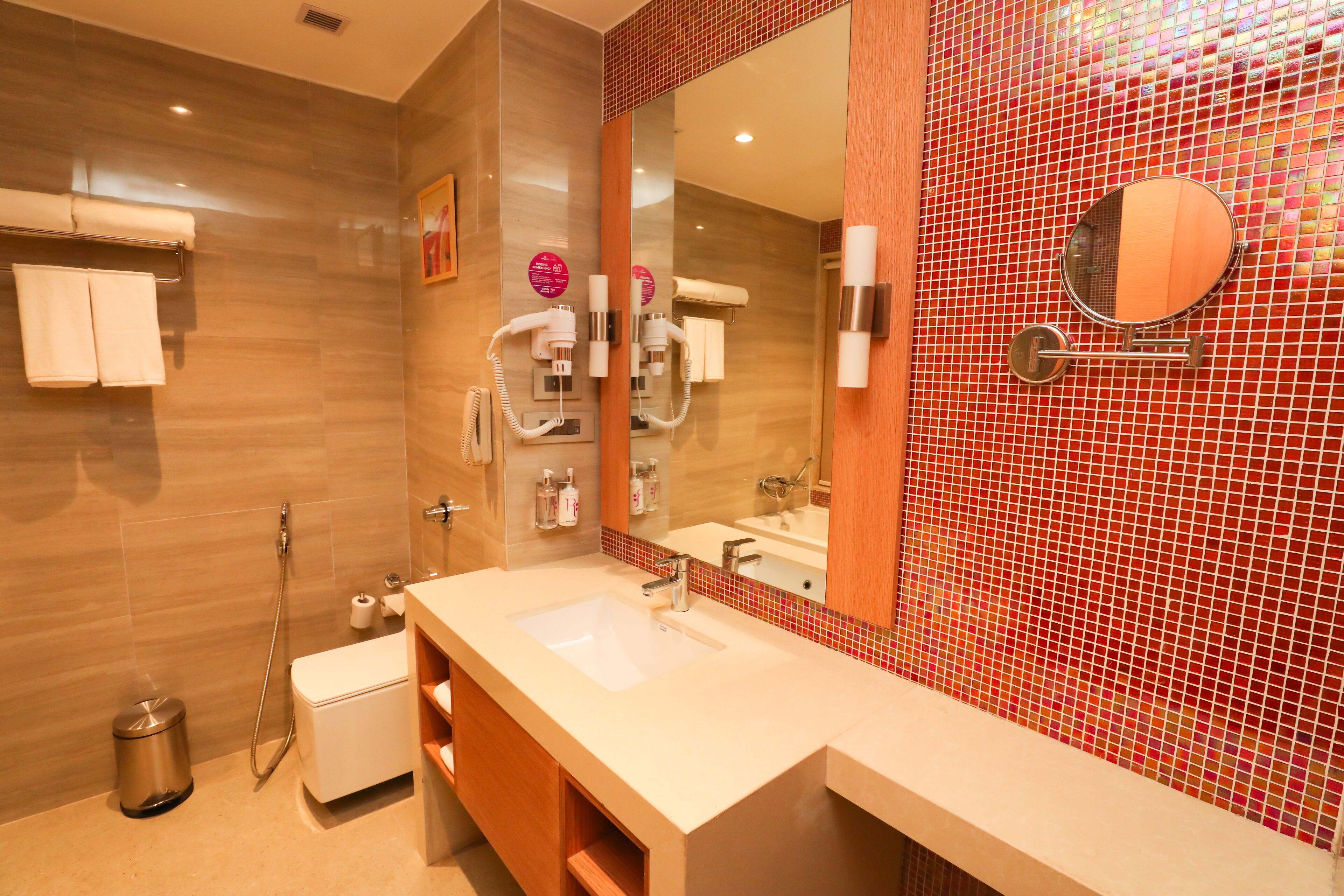 Een moderne badkamer met een grote spiegel, een wastafel en een douche.