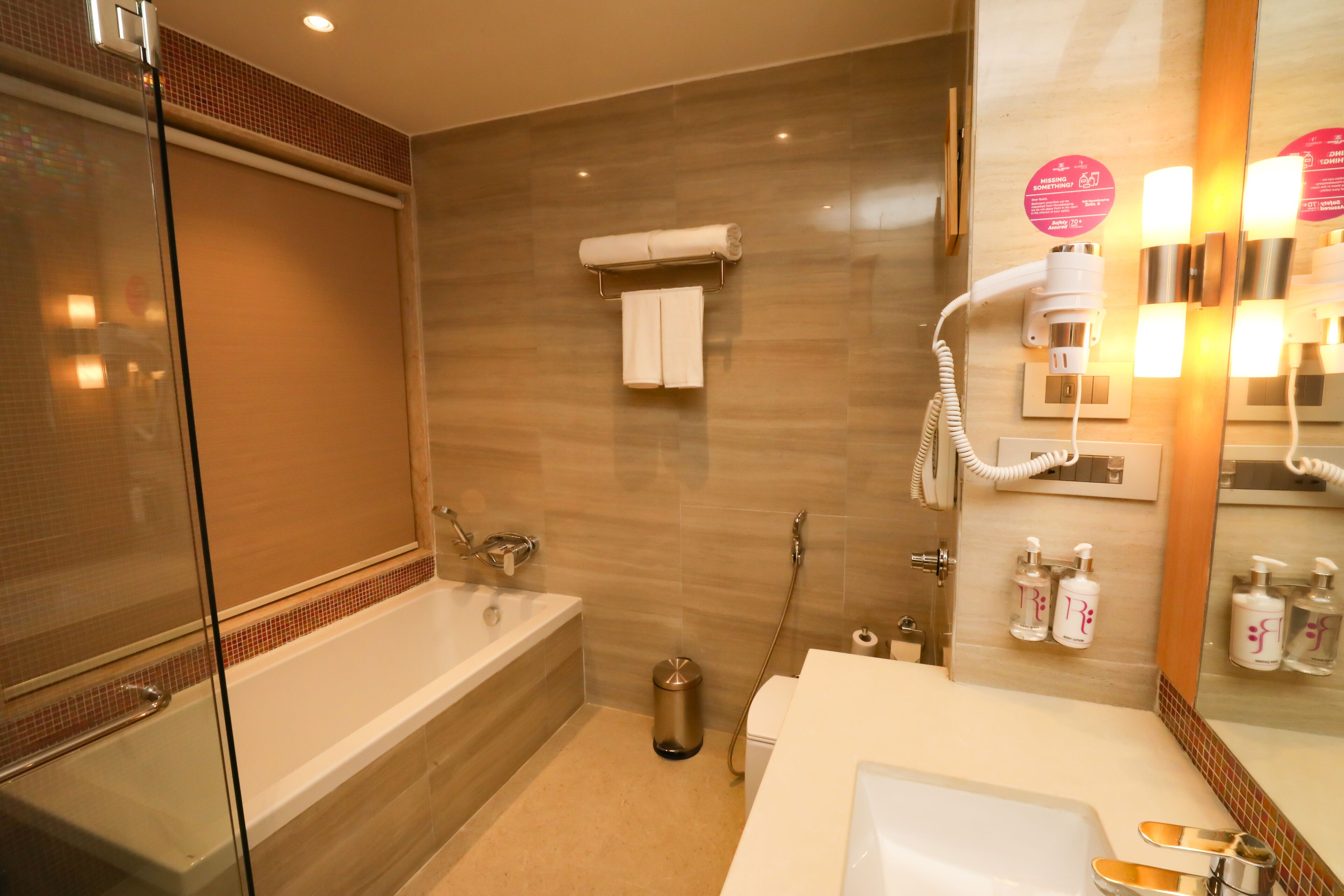 Un baño moderno con cabina de ducha de vidrio, bañera, inodoro y zona de lavamanos con espejo.