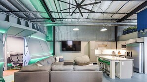 A modern kitchen with stainless steel appliances, a dining area with a table and chairs, and a seating area with a sofa and a chair. - Area 51 | Private Micro Pool-Resort | Pets OK (Hurricane)