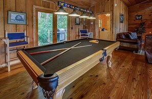 A pool table in a wooden room with a view of greenery outside. - 10 min to Soaky mntns & shoping, private backyard (Sevierville)