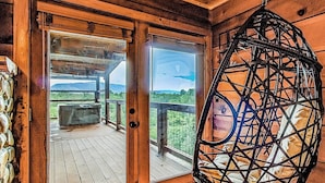 A wooden cabin with a deck, a hanging chair, and a view of the mountains. - 10 min to Soaky mntns & shoping, private backyard (Sevierville)