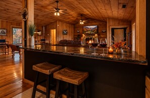 A wooden interior with a bar area, seating, and a fireplace. - 10 min to Soaky mntns & shoping, private backyard (Sevierville)