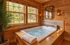 A wooden cabin interior with a large bathtub, wooden walls, and windows overlooking a garden. - 10 min to Soaky mntns & shoping, private backyard (Sevierville)