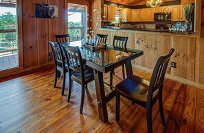 A wooden interior with a dining table and chairs, a kitchen with wooden cabinets, and a view through a window. - 10 min to Soaky mntns & shoping, private backyard (Sevierville)