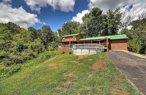 A cabin with a green roof, a covered porch, and a fenced deck area. - 10 min to Soaky mntns & shoping, private backyard (Sevierville)