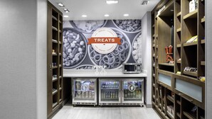 A modern interior with a 'Treats' sign, wooden shelving, and refrigerated display cases. - Hampton Inn & Suites Cedar Park North Austin (Cedar Park)