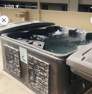 A hot tub with a stone facade, a sign indicating the use of stairs, and a timestamp.
