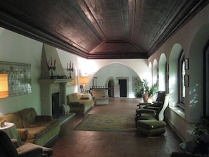 A spacious interior with a fireplace, seating area, and arched windows.
