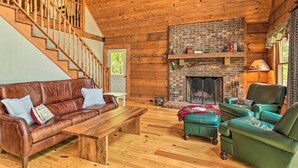 A cozy cabin interior with a wooden staircase, leather sofa, green armchairs, and a fireplace. - Game Room! Lakefront Family Cabin in Landrum (Landrum)