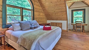 A cozy bedroom with a large bed, a desk, and a chair, all made of wood. - Game Room! Lakefront Family Cabin in Landrum (Landrum)
