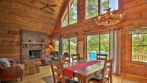 A spacious wooden cabin with a fireplace, dining area, and large windows offering views of the outdoors. - Game Room! Lakefront Family Cabin in Landrum (Landrum)