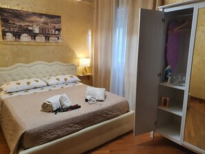 Ein Hotelzimmer mit Bett, Nachttisch, Lampe, Schrank und einem Bild an der Wand.
