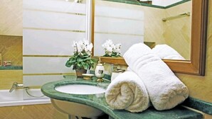 A bathroom with a green marble sink, white flowers, a towel, and a mirror. - St. Peter's Private Room (Roma)