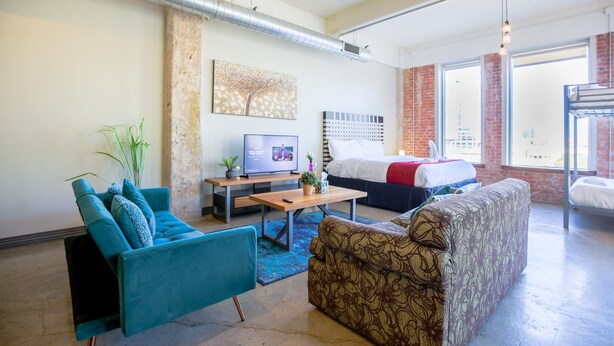Una sala de estar moderna con un sofá, una mesa de centro, un televisor y una cama.