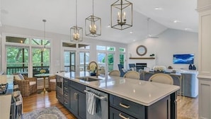 A spacious kitchen with a large island, dark cabinetry, and pendant lighting. - Hot Tub! Beautiful Mountain Views! Wifi!  Come Visit "Off the Bow"! (Huddleston)