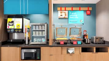 A breakfast station with a coffee machine, a refrigerator, and a toaster.