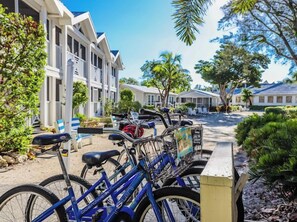 A row of bicycles parked in front of a building with a porch and outdoor seating area. - Kimball Lodge #244 - Charming 1brm, 1 and a half bath, Beachside condo! (Sanibel)